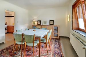a dining room with a table and chairs on a rug at Le Rocher Du Lac in Houffalize
