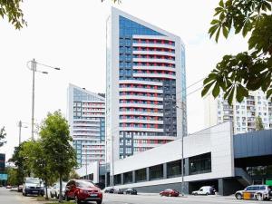 a tall building with cars parked in front of it at Smart App near Railway Station Kvartet 3C in Kyiv