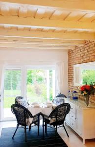 a dining room with a table and chairs and windows at Villa Arany in Balatonszemes