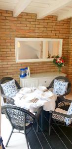 a dining table with two chairs and a table with plates at Villa Arany in Balatonszemes