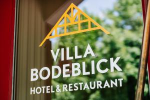 un panneau indiquant un hôtel et un restaurant dans l'établissement Hotel Villa Bodeblick, à Schierke