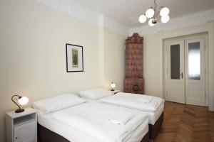 una camera con due letti con lenzuola bianche di Prague Central Exclusive Apartments a Praga