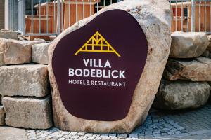 un panneau sur un rocher à côté de quelques rochers dans l'établissement Hotel Villa Bodeblick, à Schierke