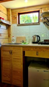 a kitchen with a counter and a sink and a window at Chatka Gargamela in Mikołajki
