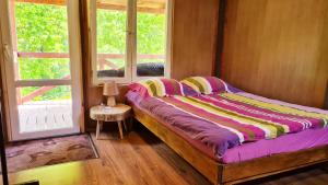 a small bed in a room with a window at Chatka Gargamela in Mikołajki