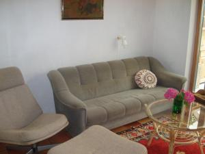 a living room with a couch and two chairs and a table at Strandhuset Holiday Home in Glyngøre