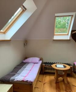a bed in a room with a window and a table at U Krzysztofa in Kopalino