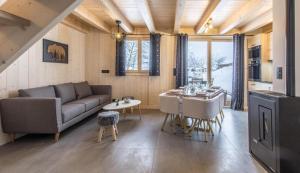 ein Wohnzimmer mit einem Sofa und einem Tisch in der Unterkunft Les Ours de Combloux in Combloux