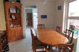 une salle à manger avec une table et des chaises en bois dans l'établissement Lavender House Weymouth, à Weymouth