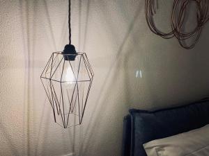 una lampada appesa a un muro in una camera da letto di Opio 60 a Montepulciano