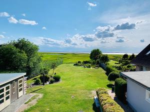 a large yard with a view of the ocean at Bungalow Seeblick Am Achterwasser in Ueckeritz +30 photos
