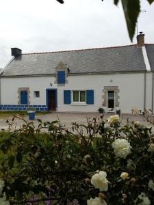 una casa blanca con adornos azules y flores en entre mer et campagne, en Damgan