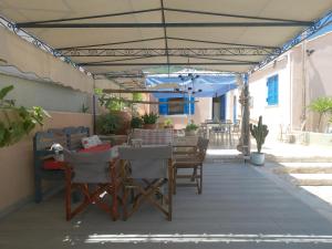 patio con tavolo e sedie sotto un pergolato di Ioniso House a Vathi