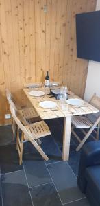 una mesa de madera con 2 sillas y una botella de alcohol en Premium Jacuzzi Central Verbier Studio, High Floor, en Verbier