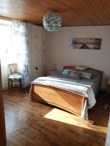 a bedroom with a bed and a chair in it at entre mer et campagne in Damgan