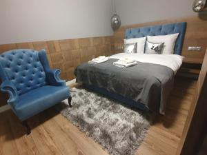 sypialnia z niebieskim łóżkiem i niebieskim krzesłem w obiekcie BALTIC PLAŻA przy plaży w mieście Krynica Morska