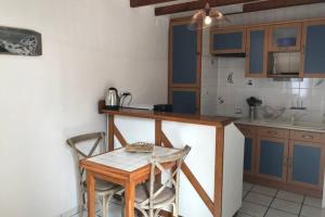 a kitchen with a table and a small table and chairs at Charmante maison de pêcheur in Barfleur
