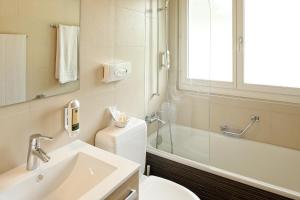 ein Badezimmer mit Waschbecken, Toilette und Dusche in der Unterkunft Hotel Bad Schwarzsee in Bad-Schwarzsee + 37 Fotos