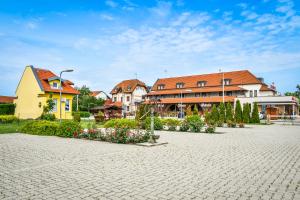 een groep huizen en een binnenplaats met bloemen bij Hotel Rózsa Csárda in Hegyeshalom