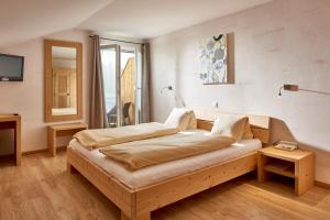 ein Schlafzimmer mit einem Bett und einem Tisch und einem Fenster in der Unterkunft Hotel Bad Schwarzsee in Bad-Schwarzsee