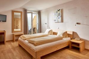 Schlafzimmer mit einem Bett, einem Tisch und einem Fenster in der Unterkunft Hotel Bad Schwarzsee in Bad-Schwarzsee