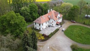 a large white house with a red roof at Dwór Komorowo in Komorowo