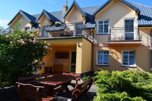 a house with a table and chairs in front of it at U Rybaka (pokoje) in Jezierzany +6 photos