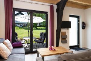 a living room with a couch and a table at Landhaus Schnorrenberg, Wellness & Nature in Hellenthal