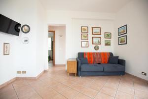a living room with a blue couch and a tv at Villa Nadia con splendida vista mare in Castellammare del Golfo