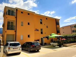 two cars parked in a parking lot in front of a building at Apartments Sunrise in Herceg-Novi