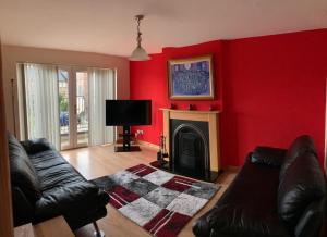 a living room with red walls and a fireplace at Lakelands in Seagoe