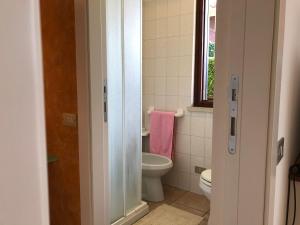 La salle de bains est pourvue de toilettes, d'un lavabo et d'une fenêtre. dans l'établissement Appartamento con Piscina a Lazise, à Lazise