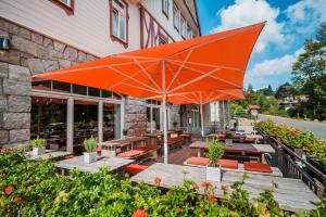 un parasol orange assis à l'extérieur d'un restaurant dans l'établissement Hotel Villa Bodeblick, à Schierke