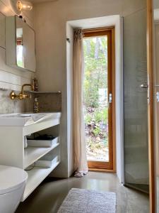 uma casa de banho com um lavatório, um WC e uma janela. em Kruthuset em Visby