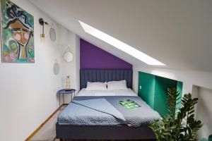 a bedroom with a bed with a purple and green wall at Different Apartments in Niš