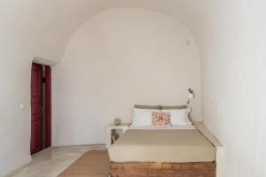 a bedroom with a bed in a white room at The sculptor's house by Cycladica in Oia