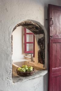 a basket of apples sitting on a counter next to a sink at The sculptor's house by Cycladica in Oia