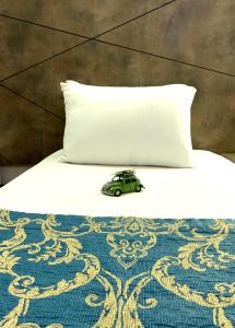 Un coche de juguete sentado en una cama junto a una almohada en Hostapark Hotel, en Mersin