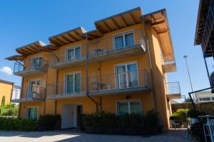a yellow building with balconies on the side of it at Residence Desiree in Riva del Garda