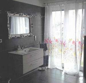 ein Bad mit einem Waschbecken, einem Spiegel und einem Fenster in der Unterkunft Ferienwohnung Schwarzwald-Baar Blick in Donaueschingen