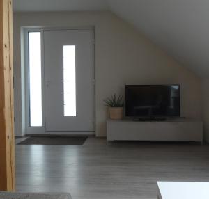 a living room with a tv and a sliding door at Ferienwohnung Schwarzwald-Baar Blick in Donaueschingen