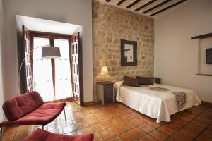 
a hotel room with a bed, table and chairs at Alvaro de Torres Boutique in Úbeda
