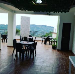 ein Esszimmer mit Tischen und Stühlen und einem großen Fenster in der Unterkunft Hotel Anzea in Anserma