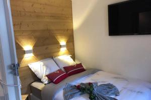 a bedroom with a bed with two pillows and a television at Chamonix sud -Le Grepon in Chamonix-Mont-Blanc