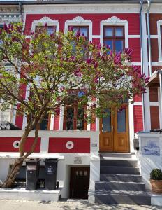 un edificio rojo y blanco con un árbol delante de él en Casa Feliz en Bremen