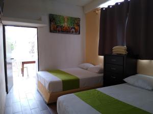 Habitación de hotel con 2 camas y ventana en Los Bungalitos en Rincon de Guayabitos
