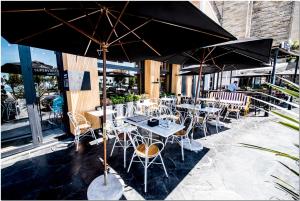 
a patio area with tables, chairs and umbrellas at DeptosVip - Gascón in Mar del Plata
