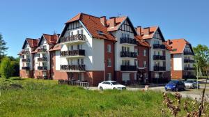 duży budynek z zaparkowanymi przed nim samochodami w obiekcie Apartament Ohar w Sztutowie +10 zdjęć