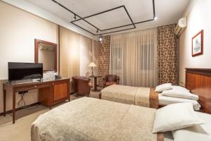 The Regent Club Hotel في نيشْ: غرفة فندقية بسريرين وتلفزيون
