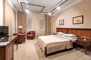 ein Hotelzimmer mit einem Bett und einem TV in der Unterkunft The Regent Club Hotel in Niš
